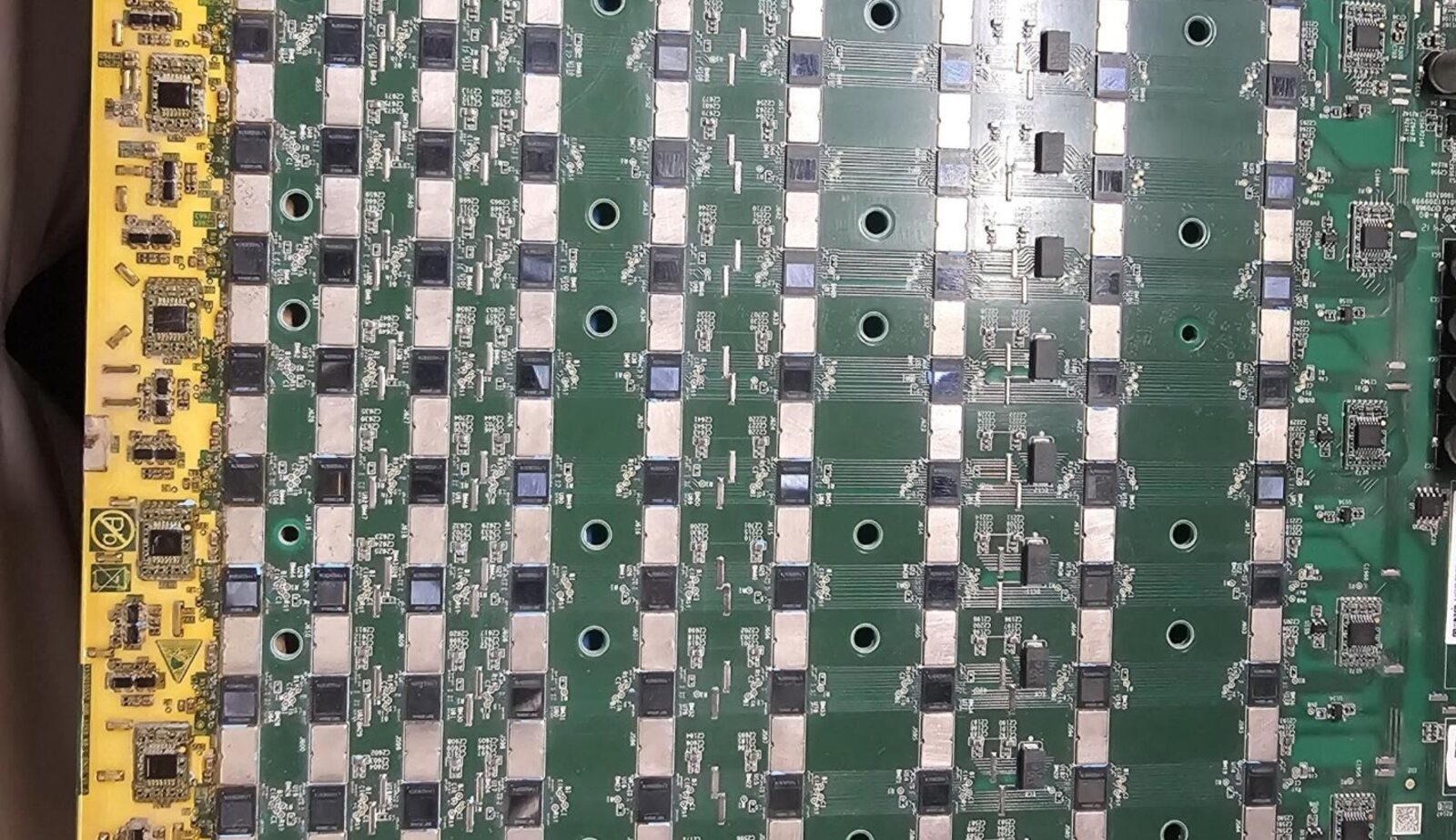 Workbench covered in ASIC hashboards being triaged as working, repairable, or donor boards